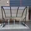 Fietsoverkapping Velo - Compact en Voordelig 19 Transparante fietsoverkapping 2.5 meter met fietsnietjes op betonplaat.